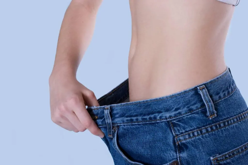 Close-Up Of A Person Pulling Loose Jeans To Show A Slim Waist in Chesterfield, MO | Forever Weight Loss Clinic