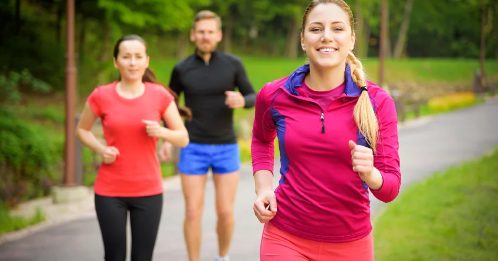 Smiling friends running outdoors in a green park trail in Chesterfield, MO | Forever Weight Loss Clinic